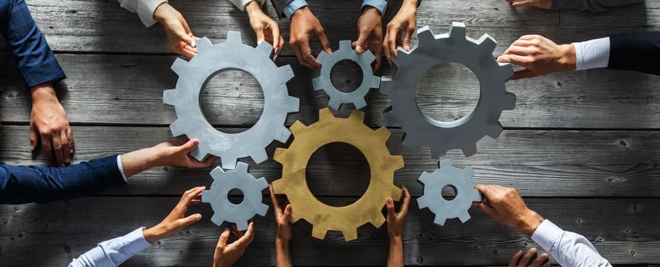 Business people holding gears- 10 QUESTIONS TO MARKETING TECHNOLOGISTS- Flawless Inbound
