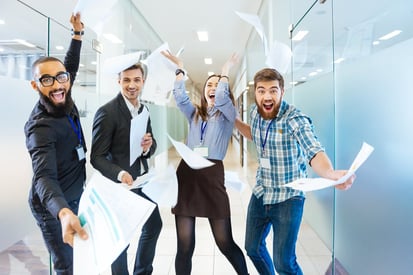 Group of joyful excited business people throwing papers and having fun in office- Sales & Marketing alignment- Flawless Inbound
